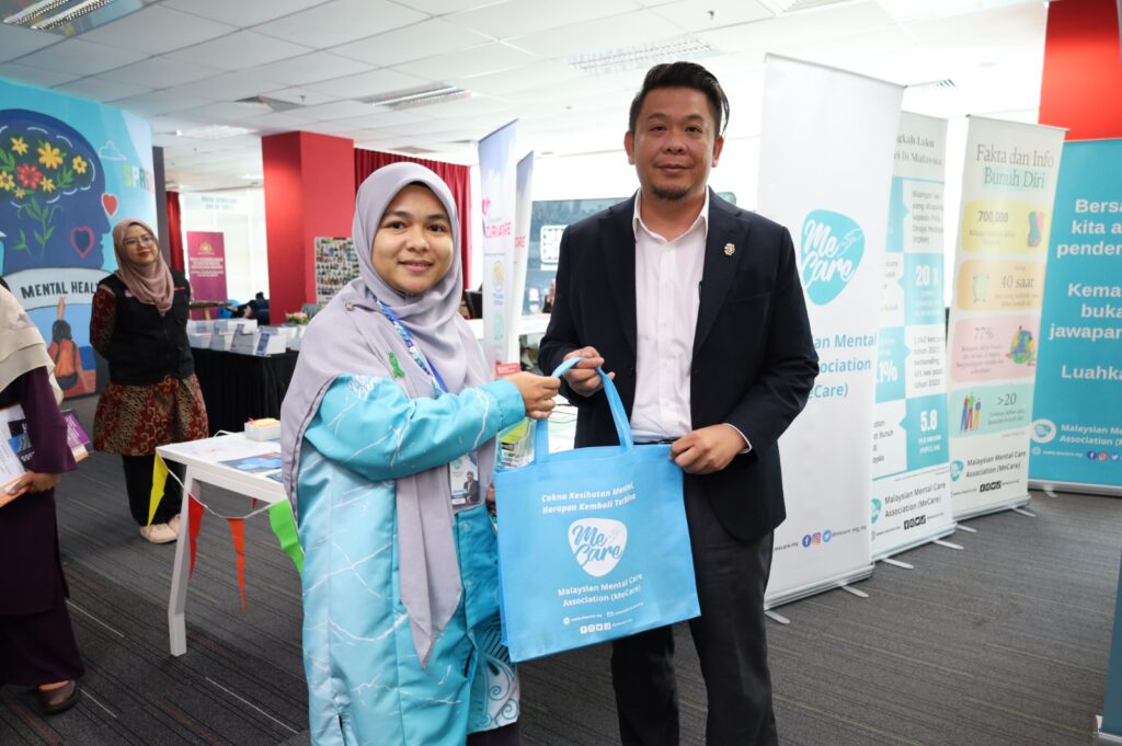 Puan Nur Areefah Binti Che Ahmad Tantowi, Pengerusi MeCare menyerahkan sedikit cenderahati kepada YB Tuan Lukanisman bin Awang Sauni, Timbalan Menteri Kesihatan Malaysia.